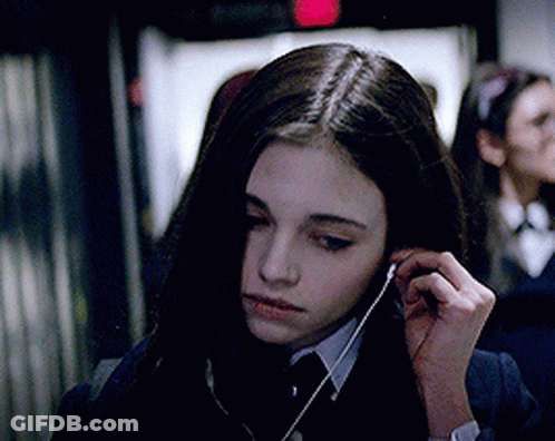 A Girl In A Suit And Tie Is Listening To Music GIF