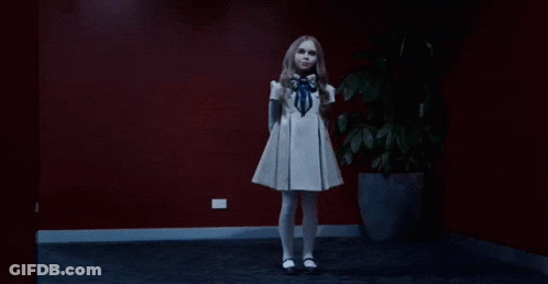 A Girl In A White Dress Is Dancing In A Dark Room GIF