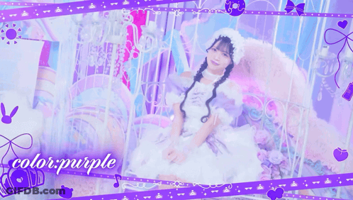 A Girl In A White Dress Is Sitting On A Bed With The Words Color Purple Behind Her GIF