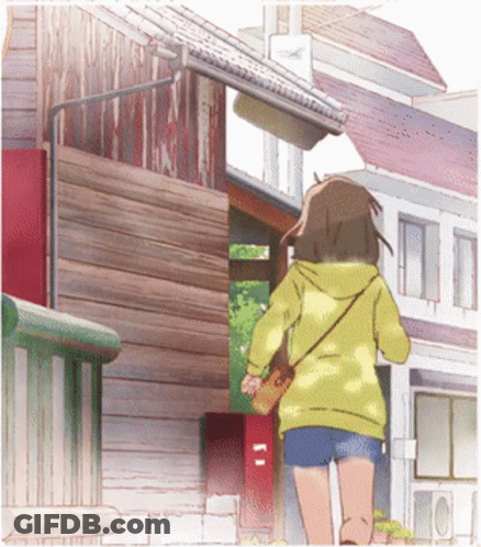 A Girl In A Yellow Hoodie And Shorts Is Walking Down A Street GIF