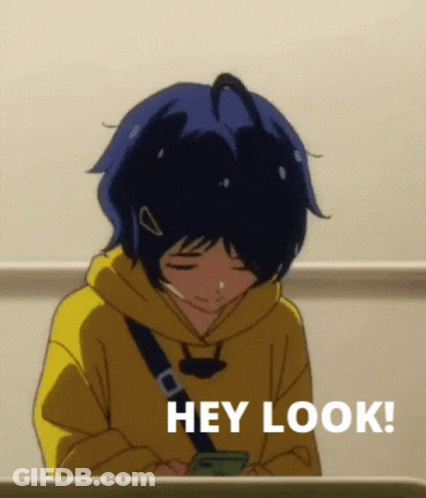 A Girl In A Yellow Hoodie Is Looking At Her Phone And Says Hey Look ! GIF