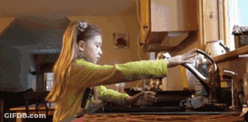 A Girl In A Yellow Shirt Is Washing Dishes In A Kitchen Sink GIF