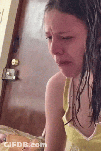 A Girl In A Yellow Tank Top Is Crying While Looking Down GIF