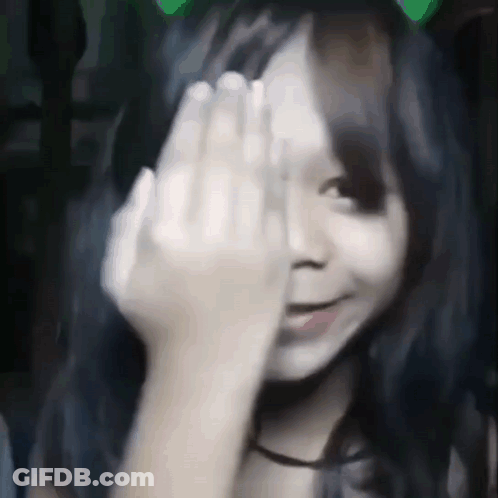 A Girl Is Covering Her Face With Her Hand . GIF