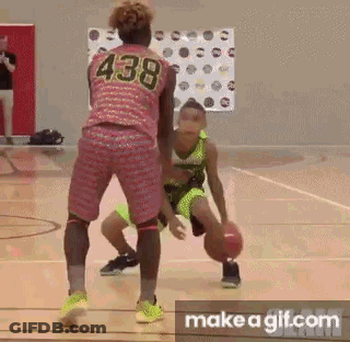 A Girl Is Dribbling A Basketball On A Basketball Court While Another Girl Tries To Stop Her . GIF