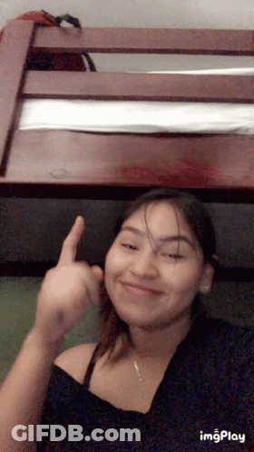 A Girl Is Giving The Middle Finger In Front Of A Bunk Bed .. GIF