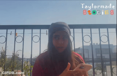 A Girl Is Holding A Cell Phone In Front Of A Taylormade Stories Banner GIF