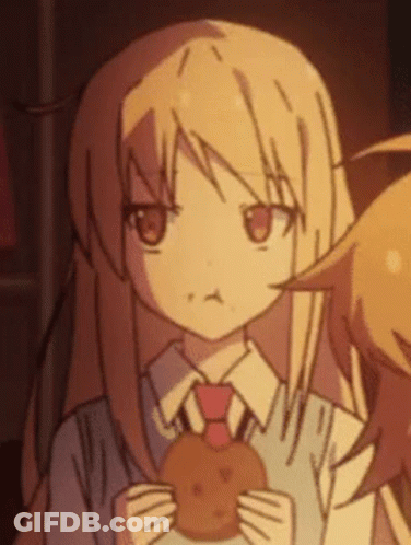 A Girl Is Holding A Cookie In Her Hands And Making A Face . GIF