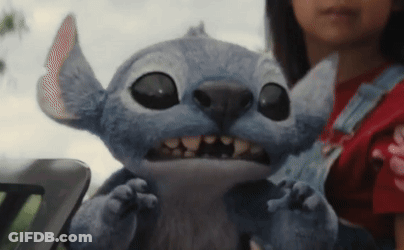 A Girl Is Holding A Stuffed Animal With Big Eyes And Teeth GIF
