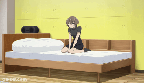 A Girl Is Kneeling On A Bed With A Yellow Wall In The Background GIF