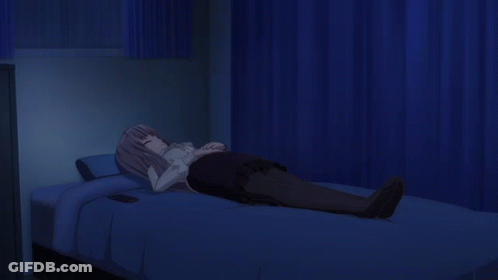 A Girl Is Laying On A Bed With A Cell Phone On The Bed GIF