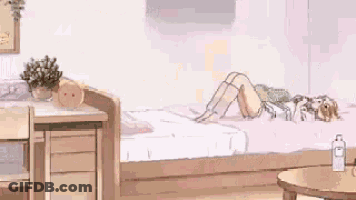 A Girl Is Laying On Her Stomach On A Bed In A Room With A Desk And A Table . GIF