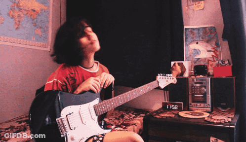 A Girl Is Playing A Guitar In Front Of A Clock That Says 8:51 GIF