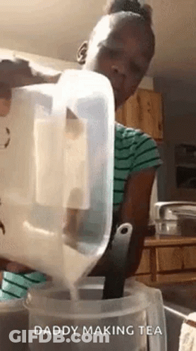 A Girl Is Pouring Milk Into A Container . GIF