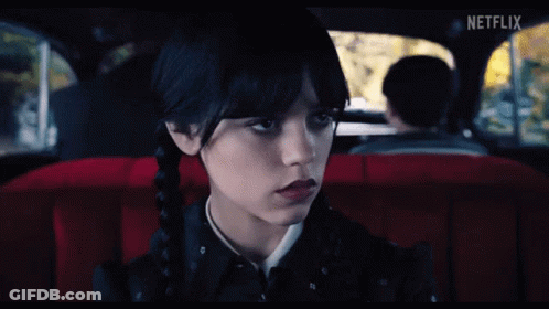 A Girl Is Sitting In The Back Seat Of A Car With A Netflix Logo On The Screen GIF