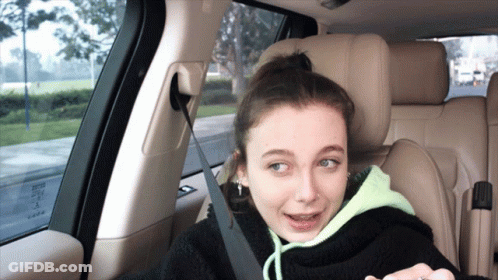 A Girl Is Sitting In The Back Seat Of A Car With A Seat Belt On GIF