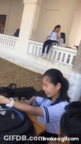A Girl Is Sitting On A Balcony Talking To Another Girl With Make A Gif.com Written Below Her GIF