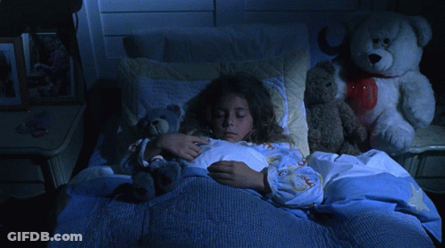 A Girl Is Sleeping In A Bed With Stuffed Animals GIF