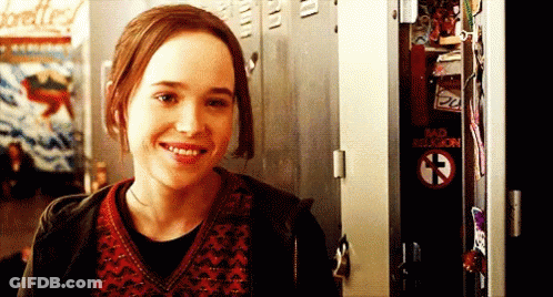 A Girl Is Smiling In Front Of A Locker That Says Bad Religion On It GIF