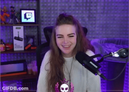 A Girl Is Smiling In Front Of A Shure Microphone . GIF
