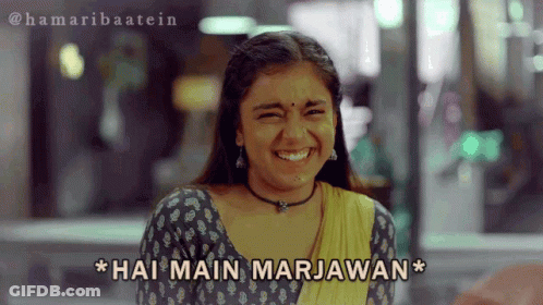 A Girl Is Smiling With The Words Hai Main Marjawan Above Her GIF