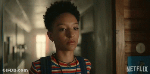 A Girl Is Standing In A Hallway With A Netflix Logo In The Background GIF