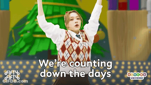 A Girl Is Standing In Front Of A Christmas Tree With The Words We 'Re Counting Down The Days Above Her GIF