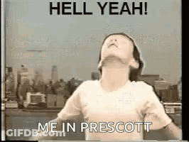 A Girl Is Standing In Front Of A City Skyline With Her Arms Outstretched And Says `` Hell Yeah ! '' GIF