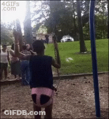 A Girl Is Swinging On A Swing In A Park With A 4Gifs.com Watermark GIF