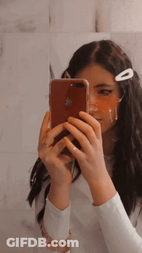 A Girl Is Taking A Picture Of Herself With An Apple Iphone GIF