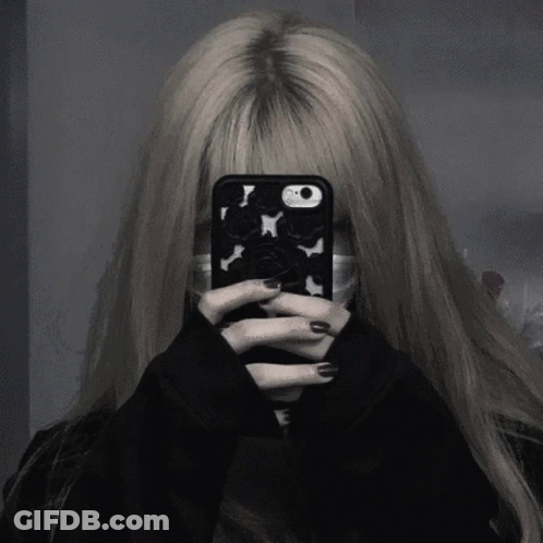 A Girl Is Taking A Selfie With Her Phone While Wearing A Mask . GIF