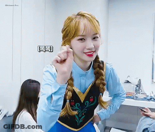 A Girl Is Wearing A Frozen Costume And Making A Heart Shape With Her Hand . GIF