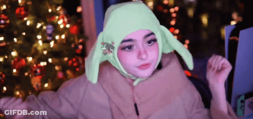 A Girl Is Wearing A Green Hat With Bunny Ears GIF