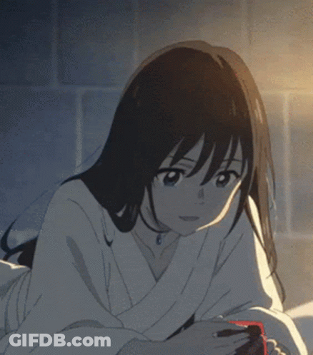 A Girl Is Wrapped In A White Blanket And Looking At Her Phone GIF
