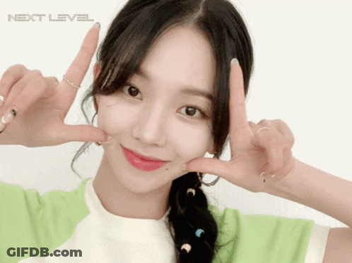 A Girl Making A Peace Sign In Front Of A White Background With The Word Next Level GIF
