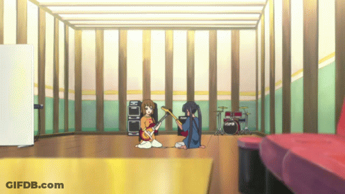 A Girl Playing A Guitar In A Room With A Drum Set GIF