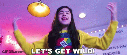 A Girl Says Let 'S Get Wild In Front Of A Sign That Says Pancakes GIF