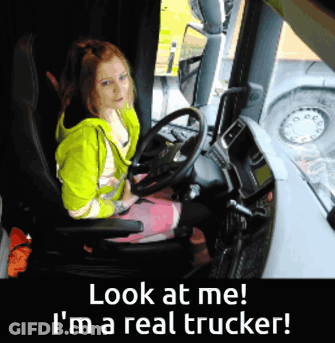 A Girl Sitting In A Truck With The Words Look At Me I 'M A Real Trucker Below Her GIF