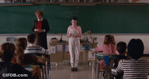A Girl Stands In Front Of A Blackboard With The Word Dignity On It GIF