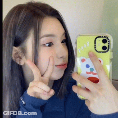 A Girl Taking A Picture Of Herself With A Case That Says Y908 GIF