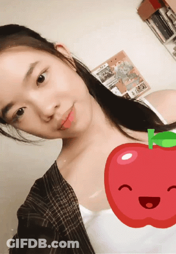 A Girl Taking A Selfie With A Red Apple In The Background GIF