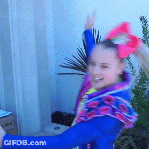 A Girl Wearing A Blue Jacket And A Pink Bow On Her Hair GIF