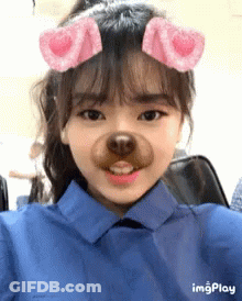 A Girl Wearing A Blue Shirt Has A Fake Dog Nose On Her Face .. GIF