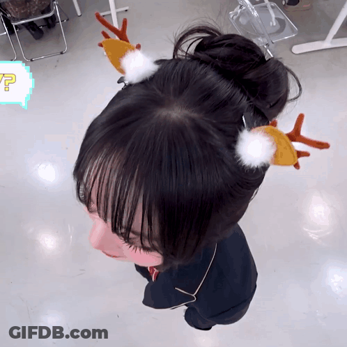 A Girl Wearing A Bun With Reindeer Antlers On Her Head GIF