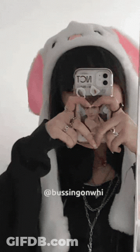 A Girl Wearing A Bunny Hat Takes A Picture Of Herself In A Mirror GIF