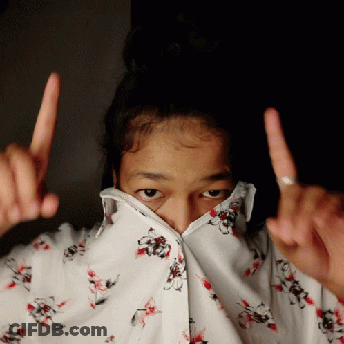 A Girl Wearing A Floral Shirt Covering Her Face With Her Fingers GIF
