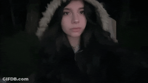 A Girl Wearing A Fur Hooded Jacket Looks At The Camera GIF