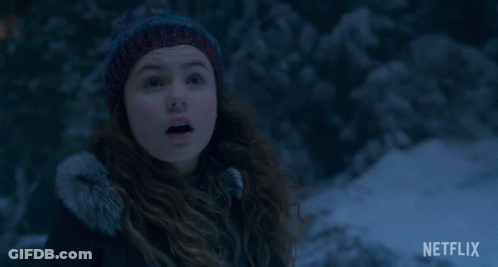 A Girl Wearing A Knitted Hat Is Smiling In The Snow With A Netflix Logo In The Corner GIF