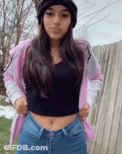 A Girl Wearing A Pink Hoodie And A Black Tank Top GIF