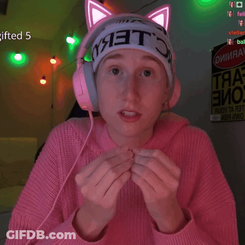 A Girl Wearing A Pink Sweater And Headphones Has A Sign That Says Gifted 5 GIF